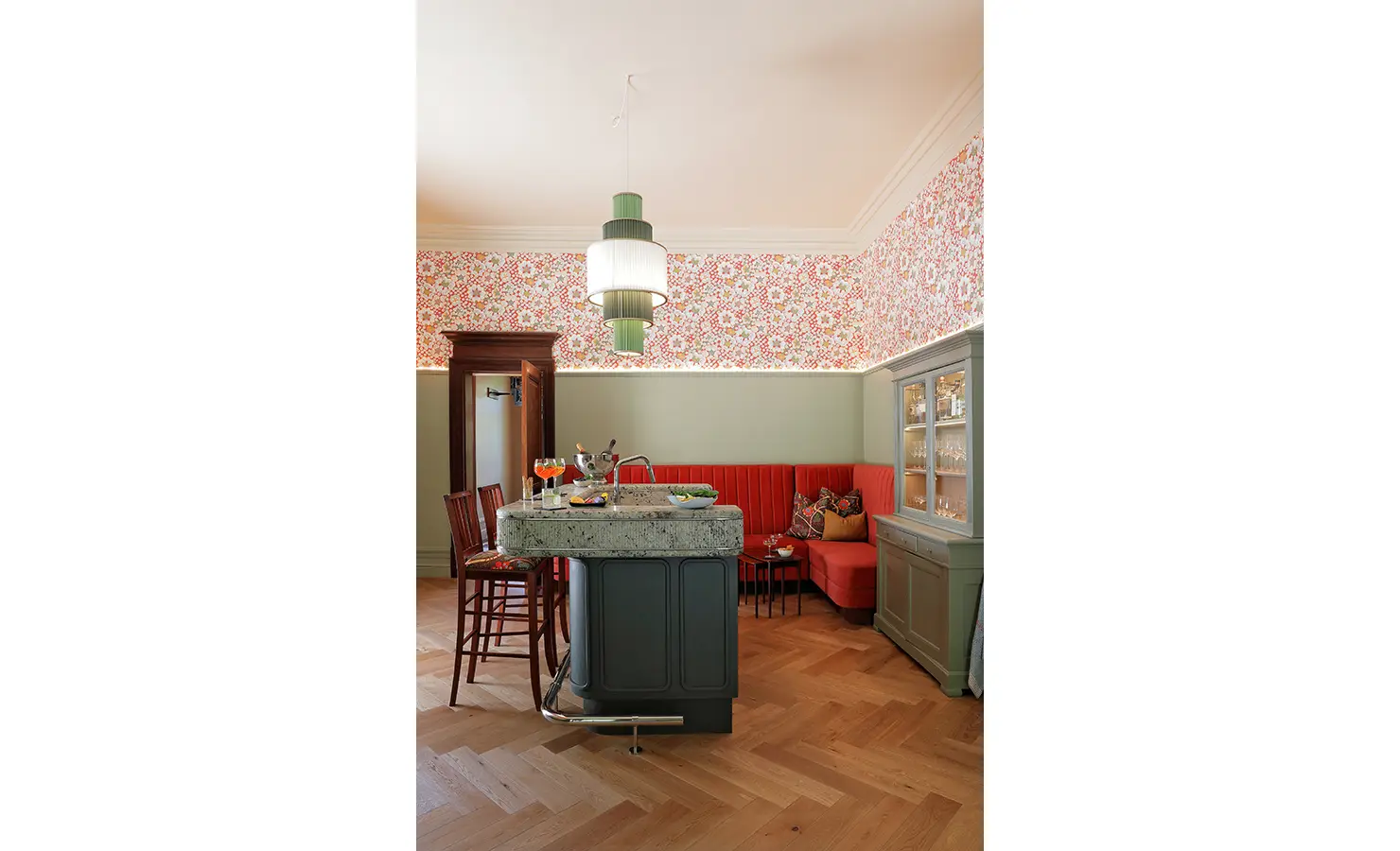 Perfect Hideaways — A stylish bar area featuring a granite-topped counter, floral wallpaper, and a coral-red banquette. The mix of muted green cabinetry and warm lighting creates a charming, retro-inspired atmosphere. Bishopscourt, Bishops Hall.