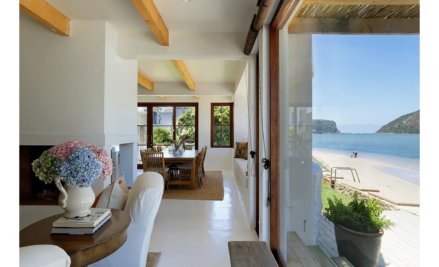 erfect Hideaways: Bright open-plan living with beamed ceilings, hydrangeas on a console and sweeping beach-and-lagoon views, Knysna, Tides Reach