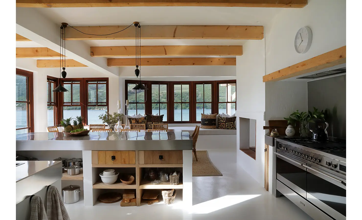 Perfect Hideaways: Sleek kitchen with stainless island and range, blonde timber beams and picture windows framing lagoon and hill views, Knysna, Tides Reach
