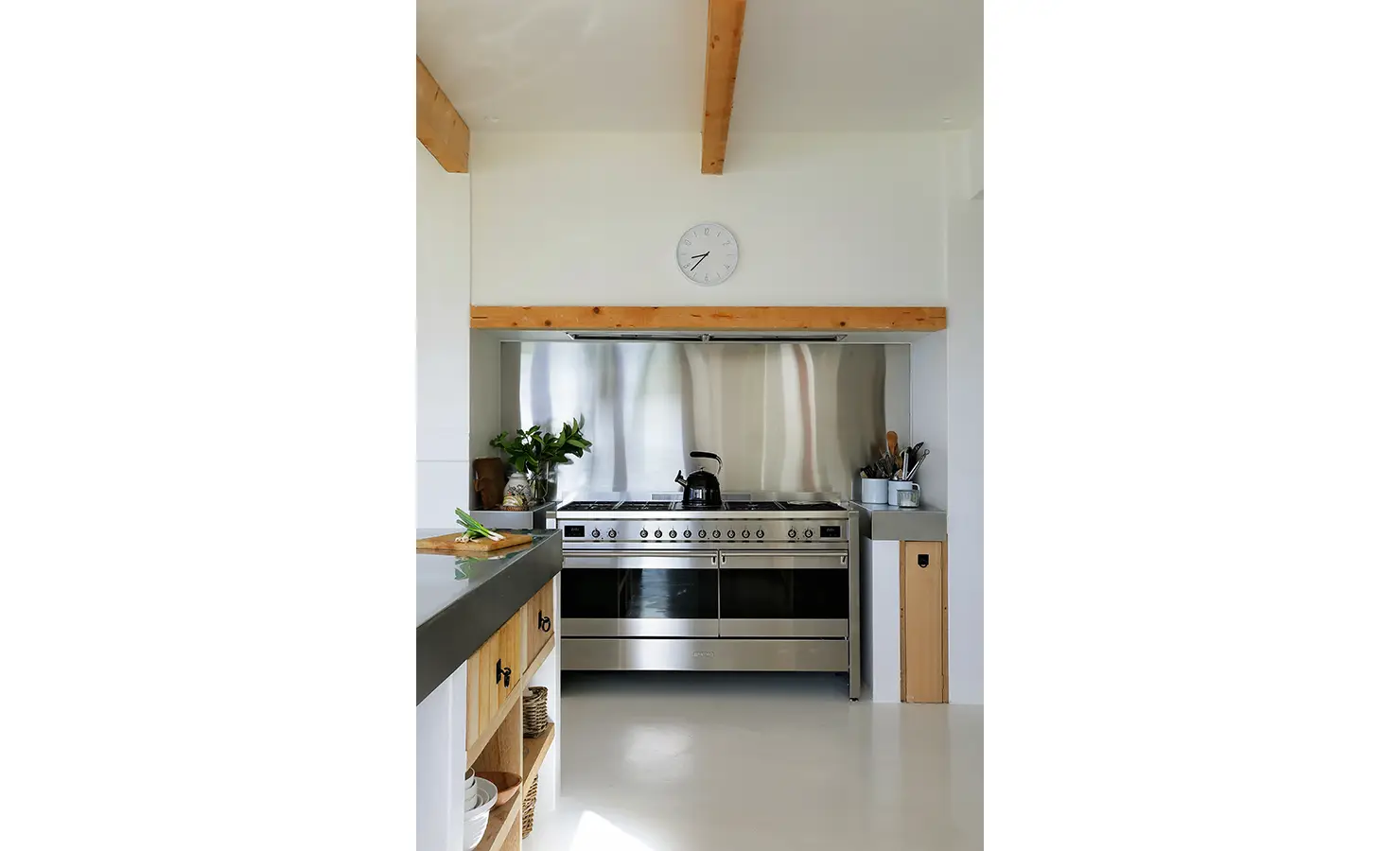Perfect Hideaways: Professional stainless-steel range with clocked hood and warm timber detailing in a crisp white kitchen, Knysna, Tides Reach