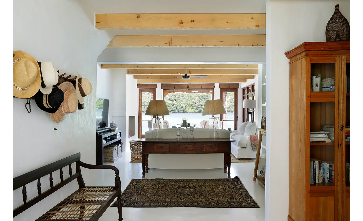 Perfect Hideaways: Entrance hall with hat rack leading to a light lounge framed by timber doors and lagoon views beyond, Knysna, Tides Reach