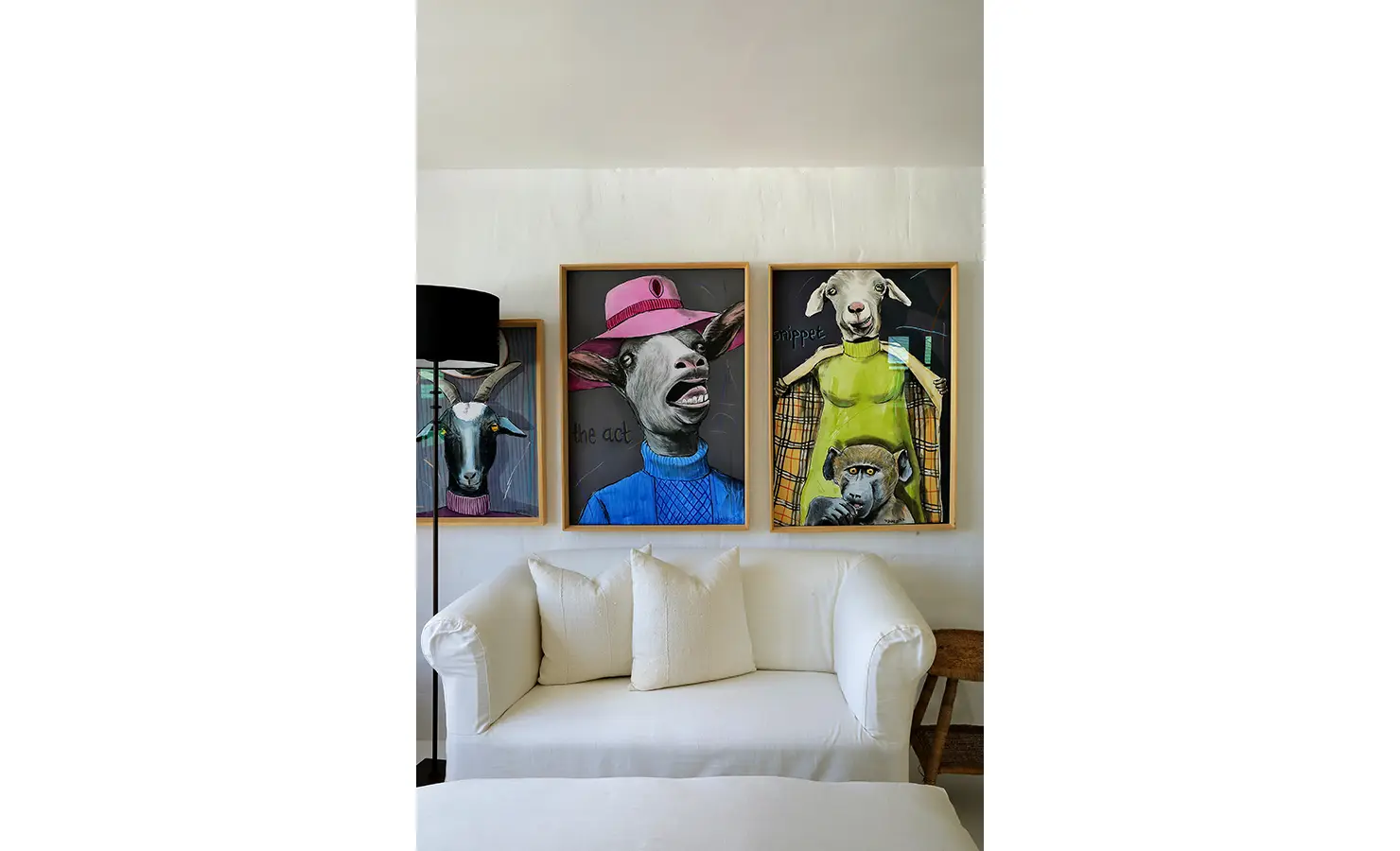 Perfect Hideaways: Playful portrait series above a white loveseat in a cosy snug, Knysna, Tides Reach