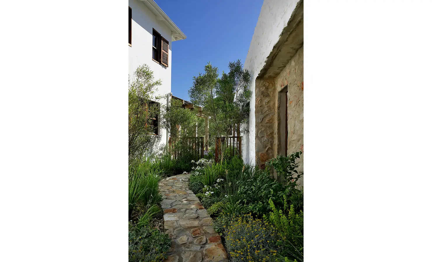 Perfect Hideaways: Leafy garden walkway with a winding stone path between whitewashed walls and lush planting, Knysna, Tides Reach