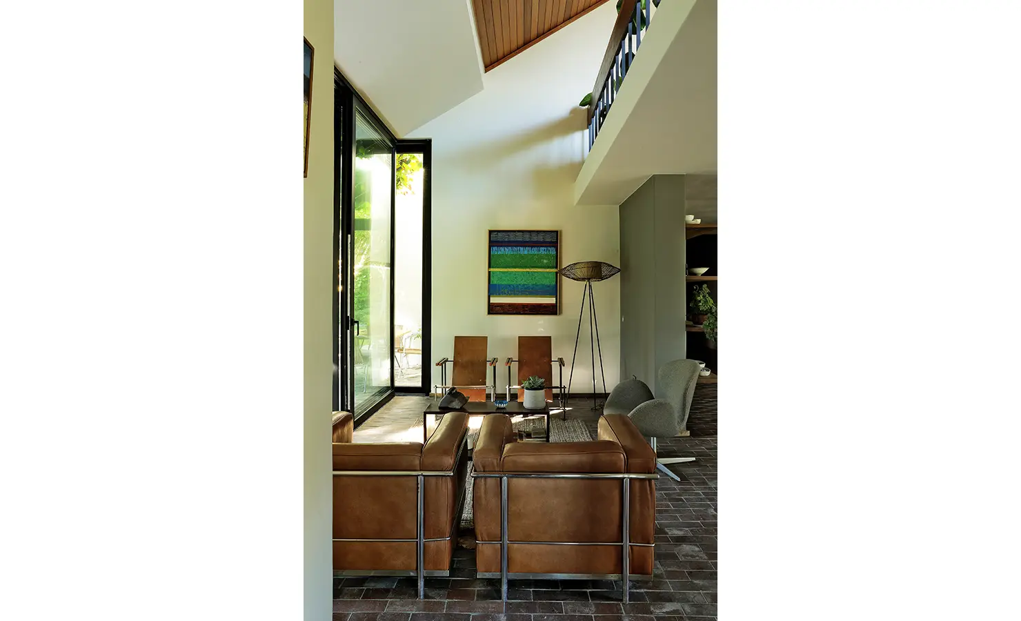 Perfect Hideaways: double-volume seating nook with modern leather armchairs, artwork and floor-to-ceiling glass opening to the garden, Franschhoek, The Garden House