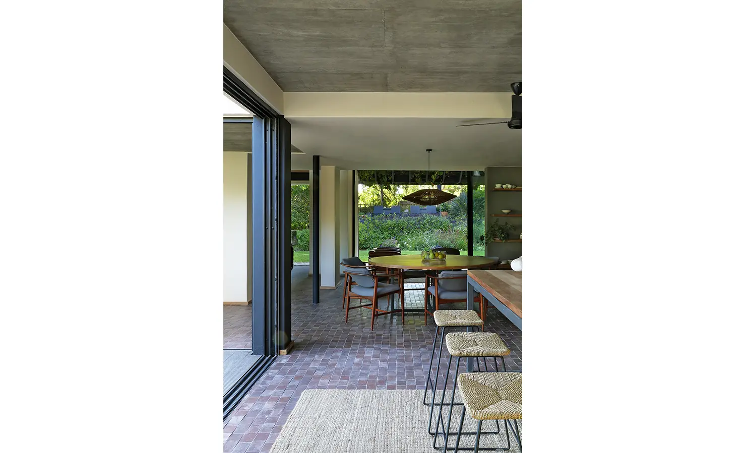 Perfect Hideaways: seamless indoor-outdoor flow from kitchen to covered dining terrace with bar stools and garden views, Franschhoek, The Garden House