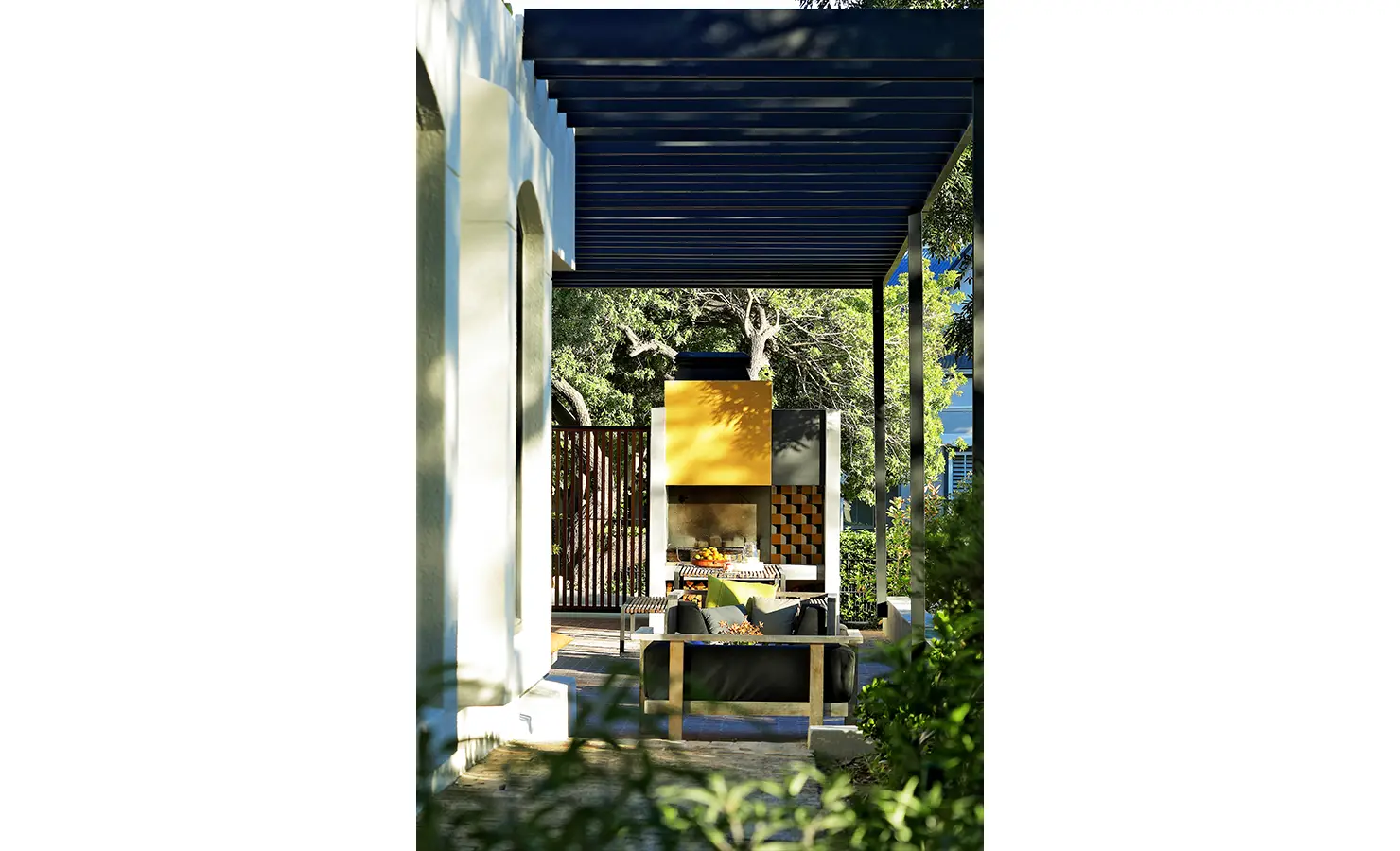 Perfect Hideaways: pergola walkway to an outdoor braai lounge with a bold yellow feature and patterned screen, Franschhoek, The Garden House