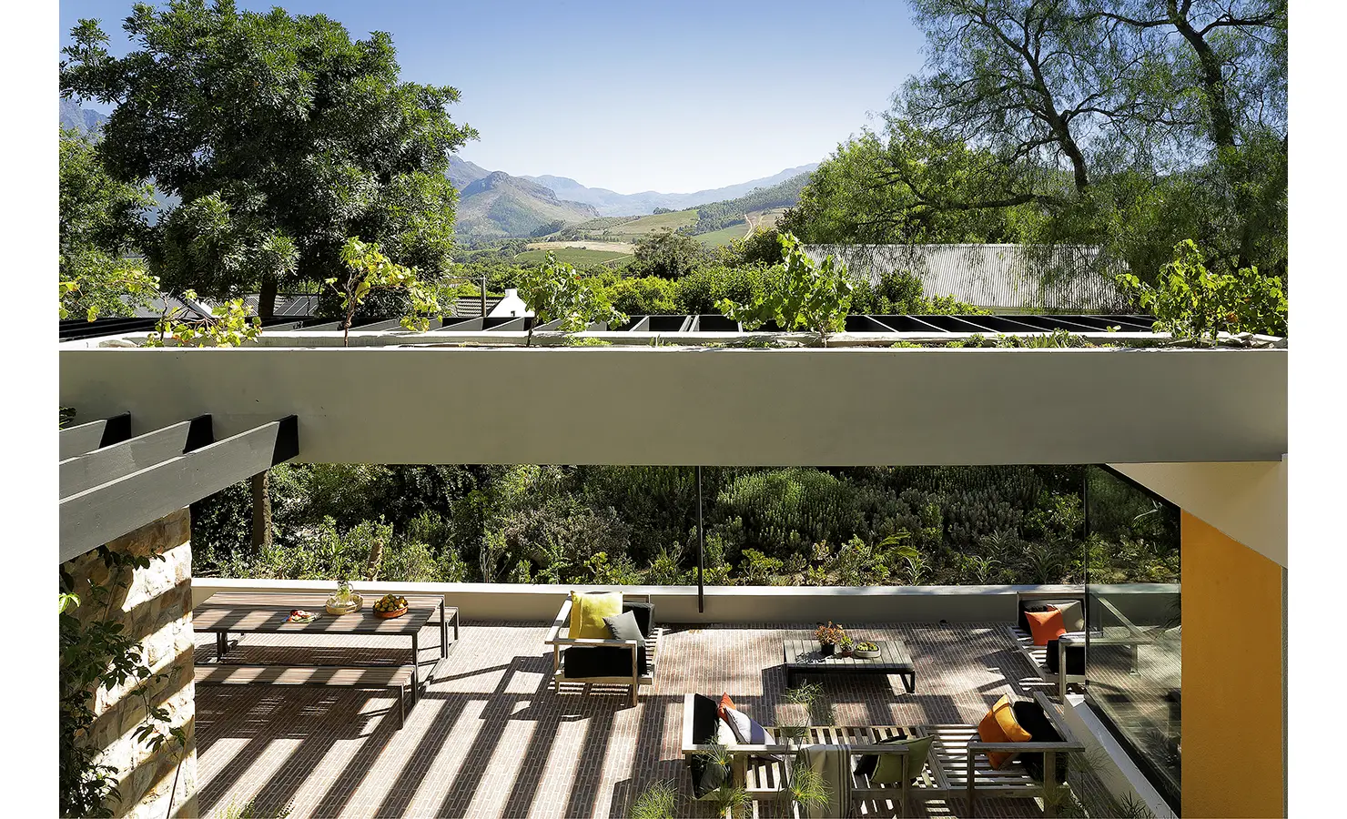 Perfect Hideaways: expansive vine-shaded terrace with multiple seating areas overlooking vineyards and mountains, Franschhoek, The Garden House