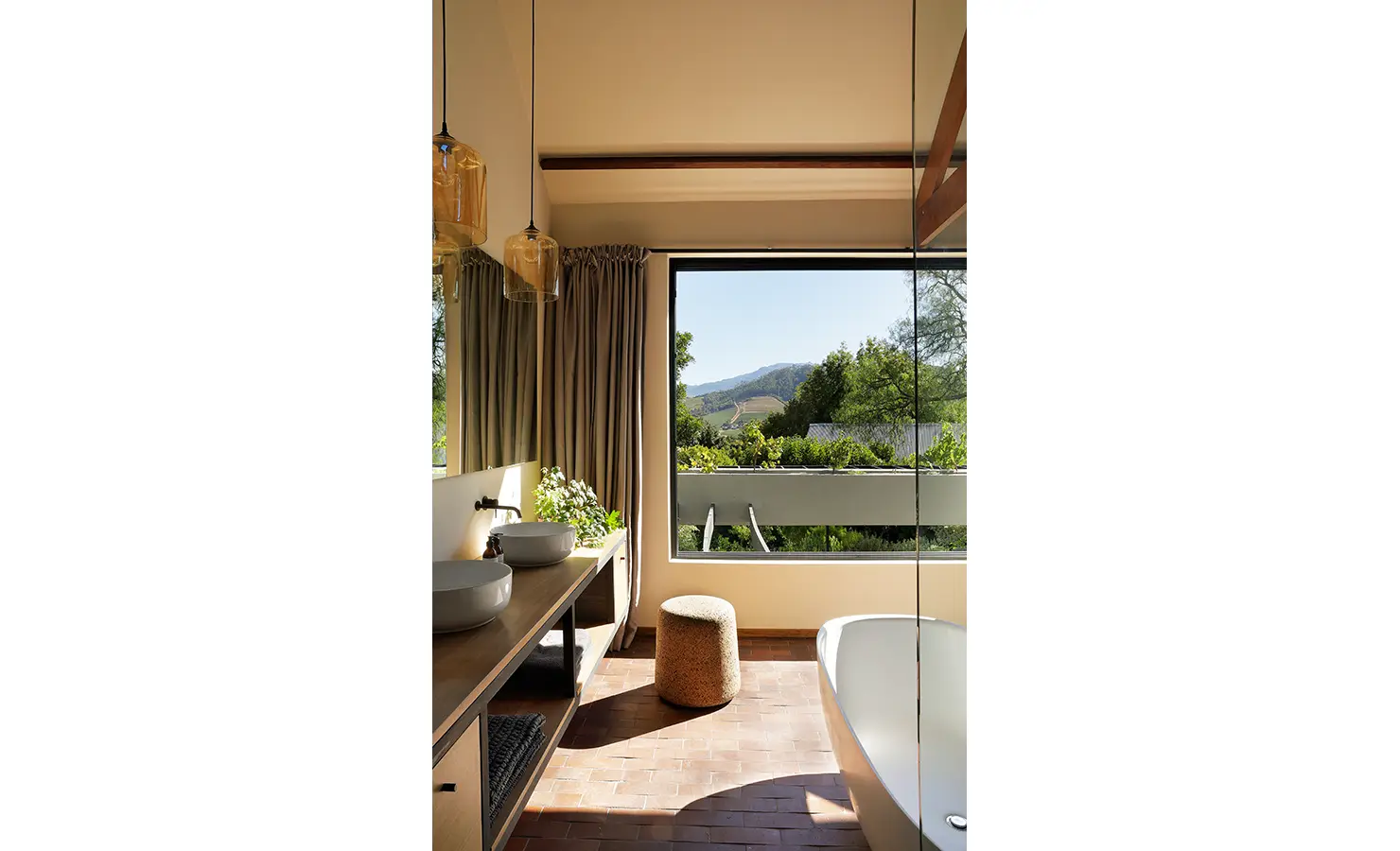 Perfect Hideaways: spa-like bathroom with freestanding tub, double basins, amber pendants and a wide vineyard outlook, Franschhoek, The Garden House