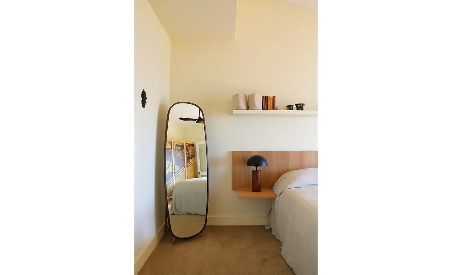 Perfect Hideaways: A calm TV room with sage green walls and open shelving flows out to a terrace with panoramic sea views, bringing the outdoors in. Simons Kloof House, Simons Town.