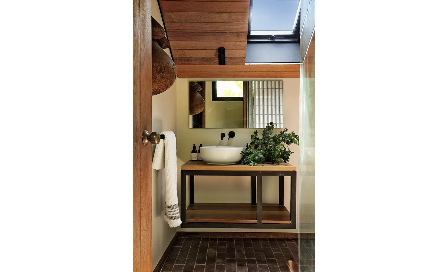 Perfect Hideaways: skylit bathroom with timber ceiling, round basin on a wooden vanity and leafy greenery beside the mirror, Franschhoek, The Garden House
