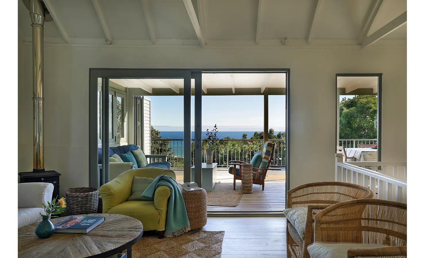 Perfect Hideaways: Lounge sliding open to the verandah with striped deck chairs and sweeping sea views — relaxed coastal living, Amongst The Trees, Scarborough.
