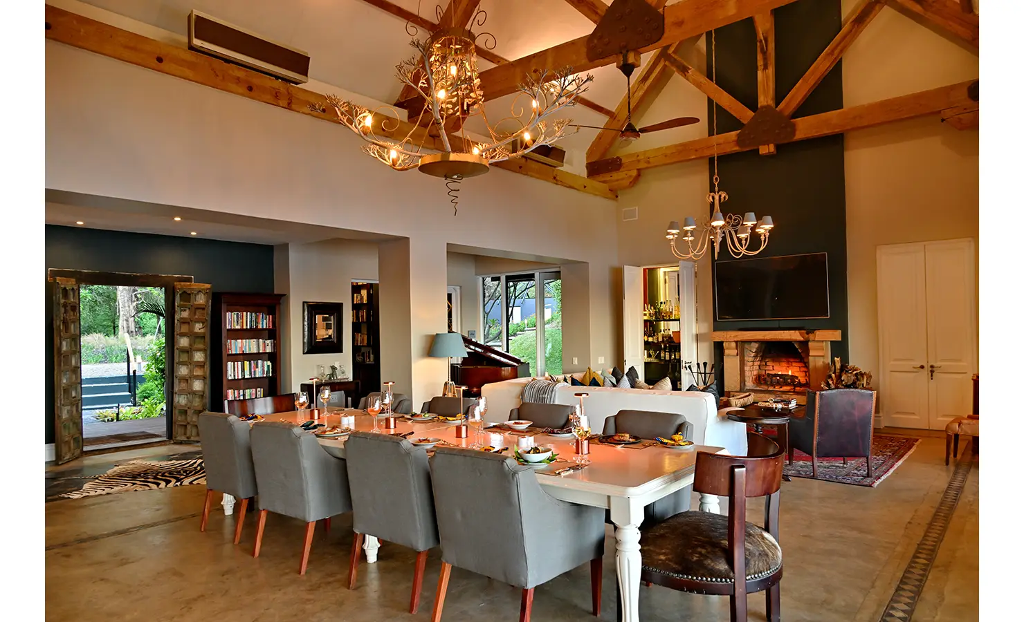 Perfect Hideaways: Spacious open-plan dining and living room with vaulted ceilings, chandeliers, and a large fireplace, Tanyati Villa, Livingstone