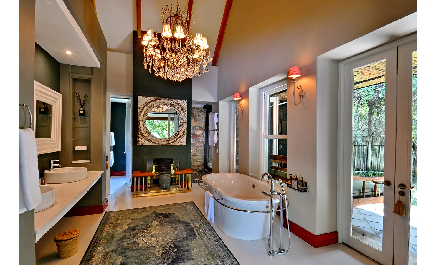Perfect Hideaways: Sophisticated bathroom with freestanding tub, chandelier lighting, and double vanities opening onto a private terrace, Tanyati Villa, Livingstone