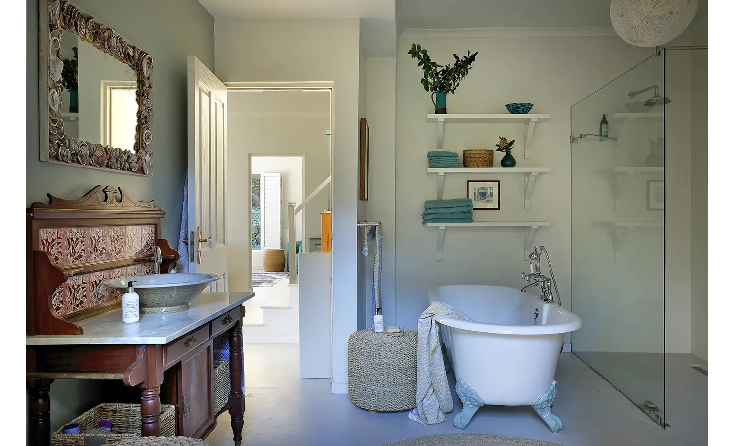 Perfect Hideaways: Family bathroom with claw-foot tub, walk-in shower and vintage vanity under a shell-trimmed mirror; towels stacked on open shelves, Amongst The Trees, Scarborough.