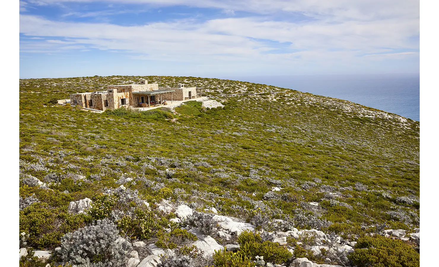 Perfect Hideaways: A wide view of the hideaway nestled deep within the untouched fynbos reserve, perched above the endless blue of the Indian Ocean. Fynbos Fort, Plettenberg Bay.