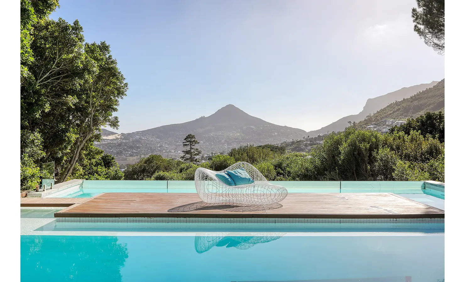 Perfect Hideaways: Infinity‑edge pool with timber island and sculptural daybed overlooking the valley and mountain peak, Spa House, Hout Bay
