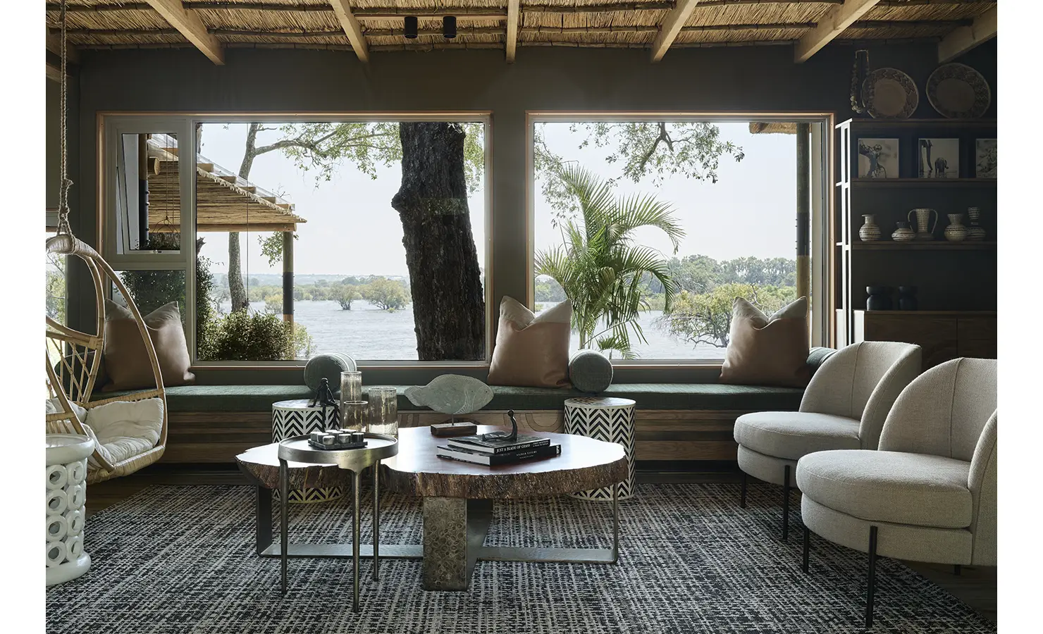 Perfect Hideaways: Cosy lounge with thatched ceiling, picture windows and a built-in bench framing wide river views, Rapid's View Villa, Zambezi National Park