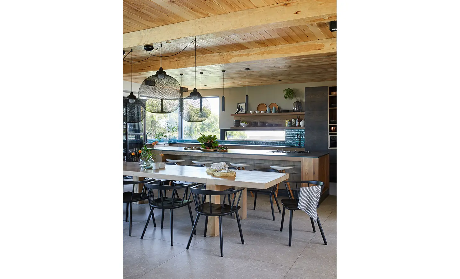 Perfect Hideaways: A spacious open-plan kitchen and dining area with wooden finishes, woven pendant lights, and large windows inviting natural light. St Austel, Kenton-on-Sea