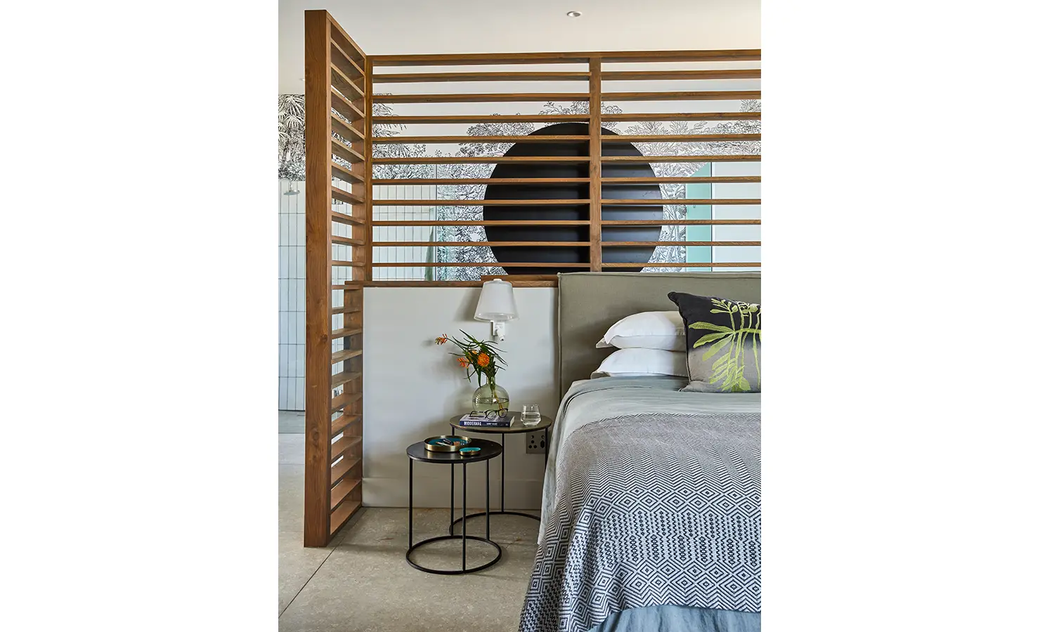 Perfect Hideaways: A serene bedroom with a patterned throw, wooden screen partition, and minimalist side tables styled with florals and books. St Austel, Kenton-on-Sea