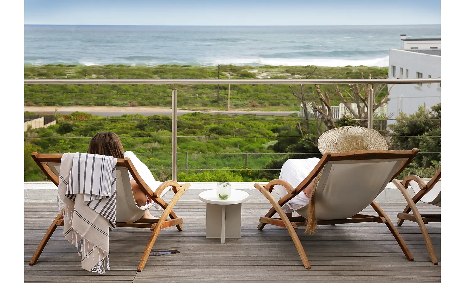 Perfect Hideaways: sea-facing balcony with wooden sling chairs and a small side table, stainless-cable balustrade and sweeping views over dunes to the ocean, Blanc de Blanc, Yzerfontein