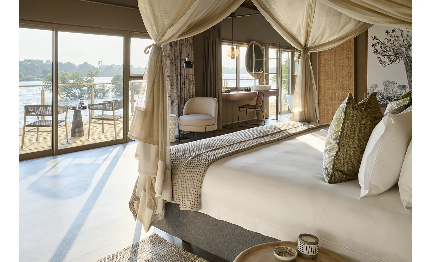 Perfect Hideaways: Elegant riverside suite with draped four-poster bed, soft neutrals and doors to a private deck, Rapid's View Villa, Zambezi National Park
