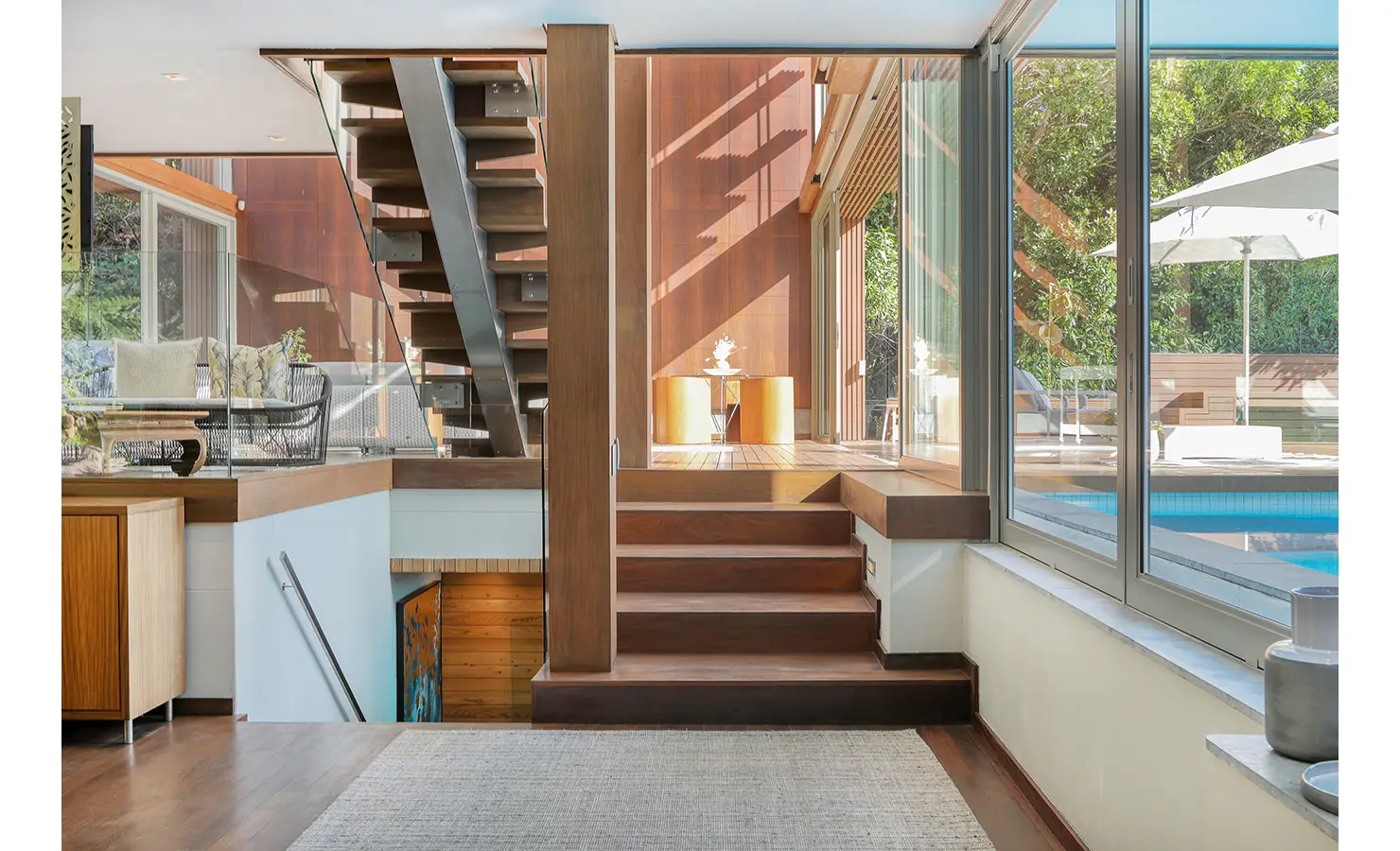 Perfect Hideaways: Split‑level interior with floating timber‑and‑steel staircase, floor‑to‑ceiling glazing and views to the pool terrace, Spa House, Hout Bay