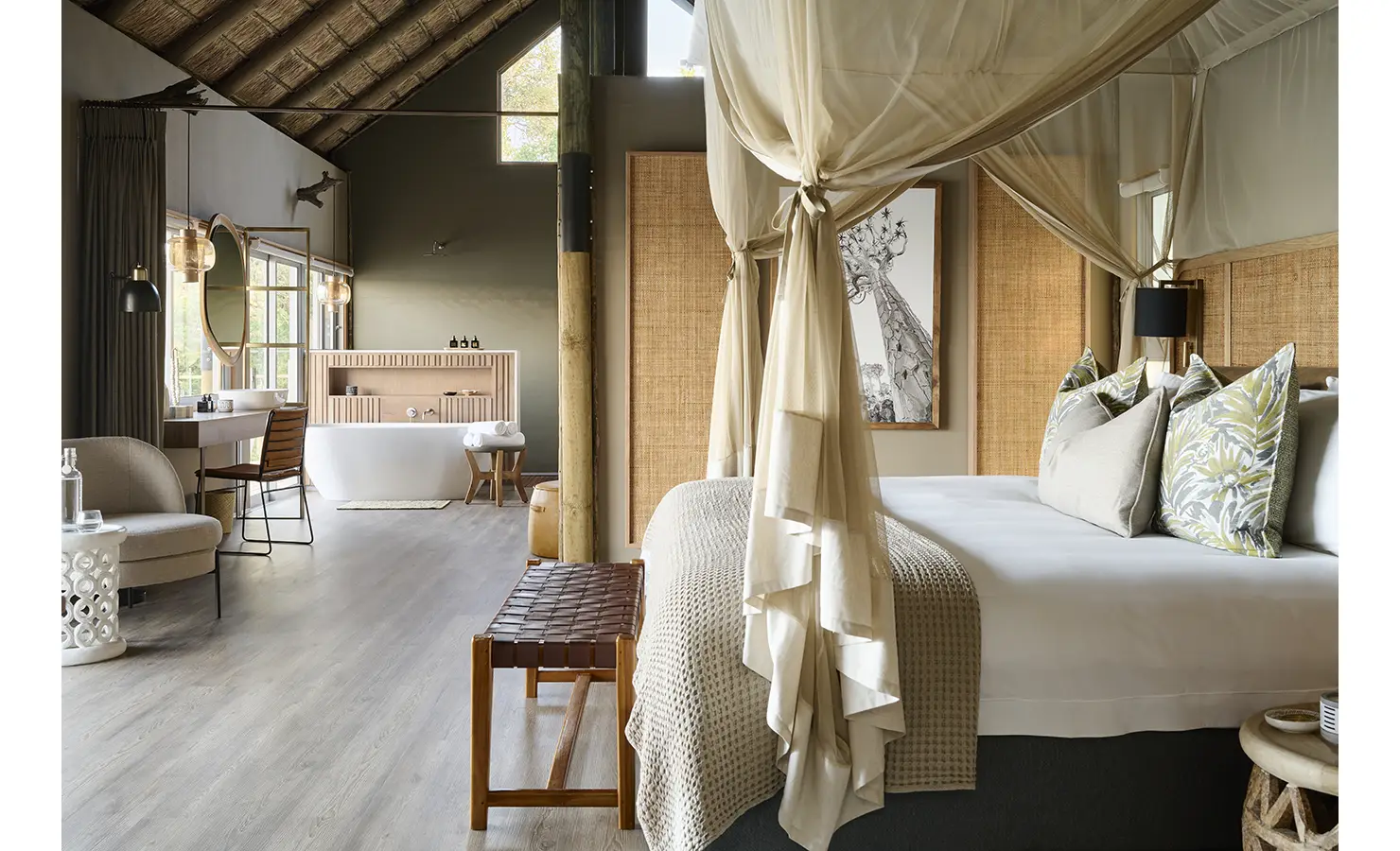 Perfect Hideaways: Spacious suite with draped four-poster bed under a thatched ceiling, seating nook and a freestanding bath in an open-plan layout, Rapid's View Villa, Zambezi National Park