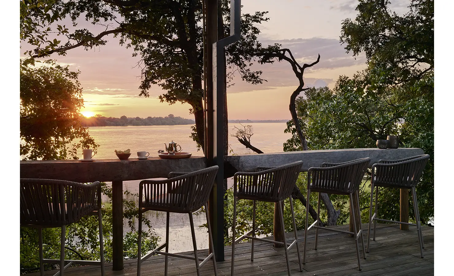 Perfect Hideaways: Elevated bar deck with high stools overlooking the river, perfect for sundowners at golden hour. Hippo Creek Villa, Zambezi National Park.