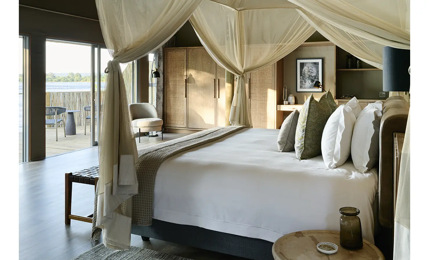 Perfect Hideaways: Canopied king bedroom in soft neutrals with sliding doors to a private river-view deck, Rapid's View Villa, Zambezi National Park