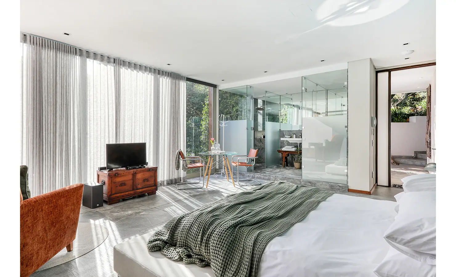 Perfect Hideaways: Light-filled suite with curtain-wall glazing, glass-box shower room and bistro table with chairs, Spa House, Hout Bay