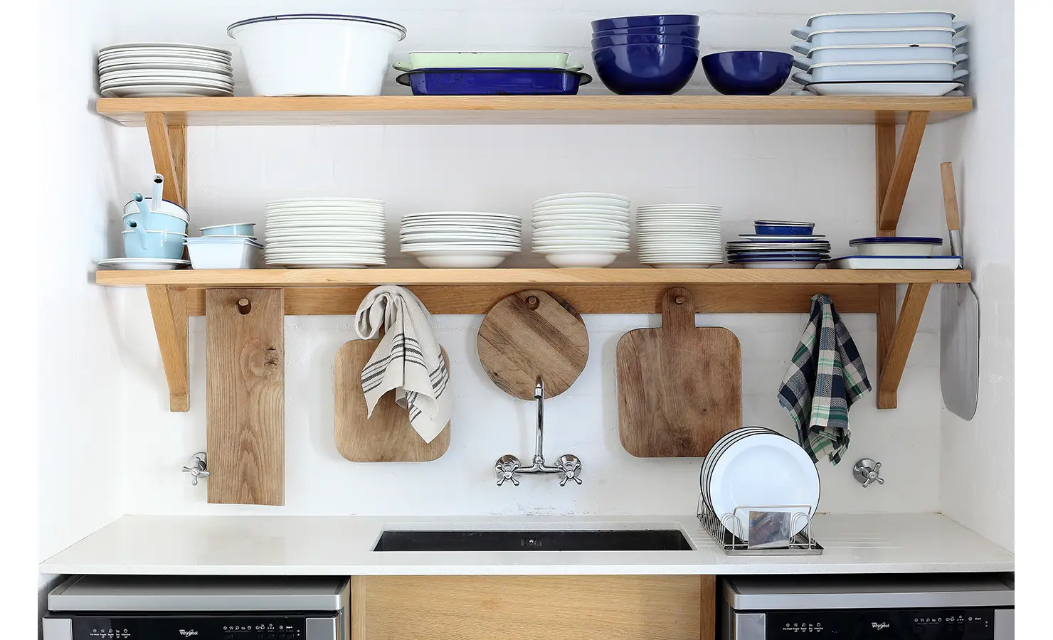 erfect Hideaways: open oak shelving with stacked white crockery, blue enamelware and hanging wooden boards above a butler’s sink, Langebaan, Lagoon Lookout.