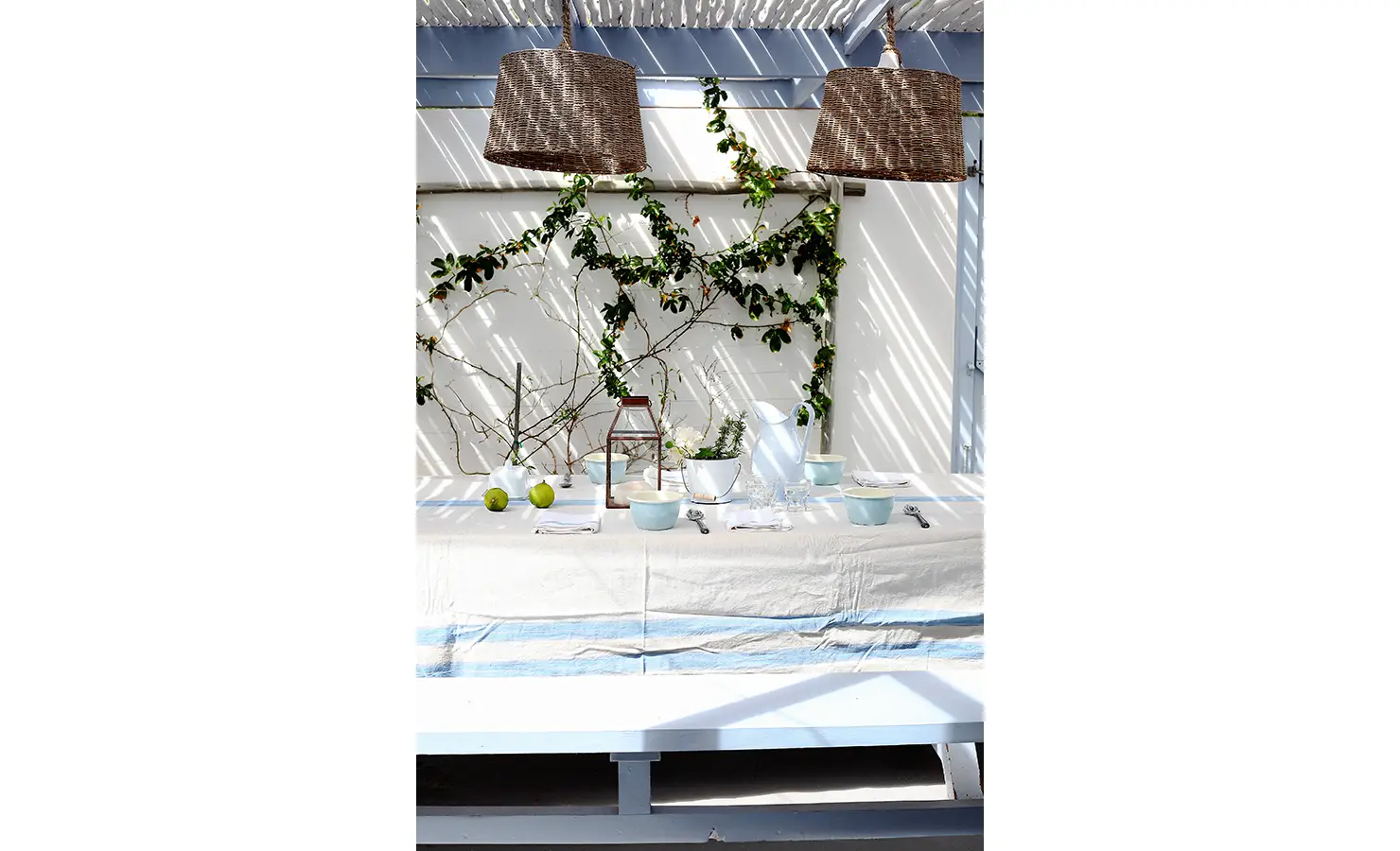 Perfect Hideaways: al fresco table dressed in blue-striped linen under woven pendants, framed by climbing vines and dappled shade, Langebaan, Lagoon Lookout.