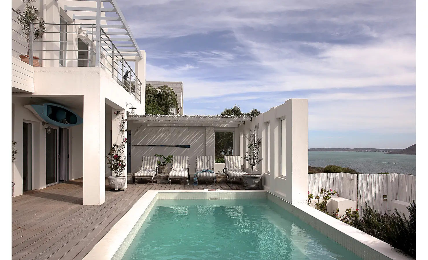 Perfect Hideaways: whitewashed coastal home with balcony and pool courtyard, shaded pergola and striped loungers overlooking the lagoon, Langebaan, Lagoon Lookout.