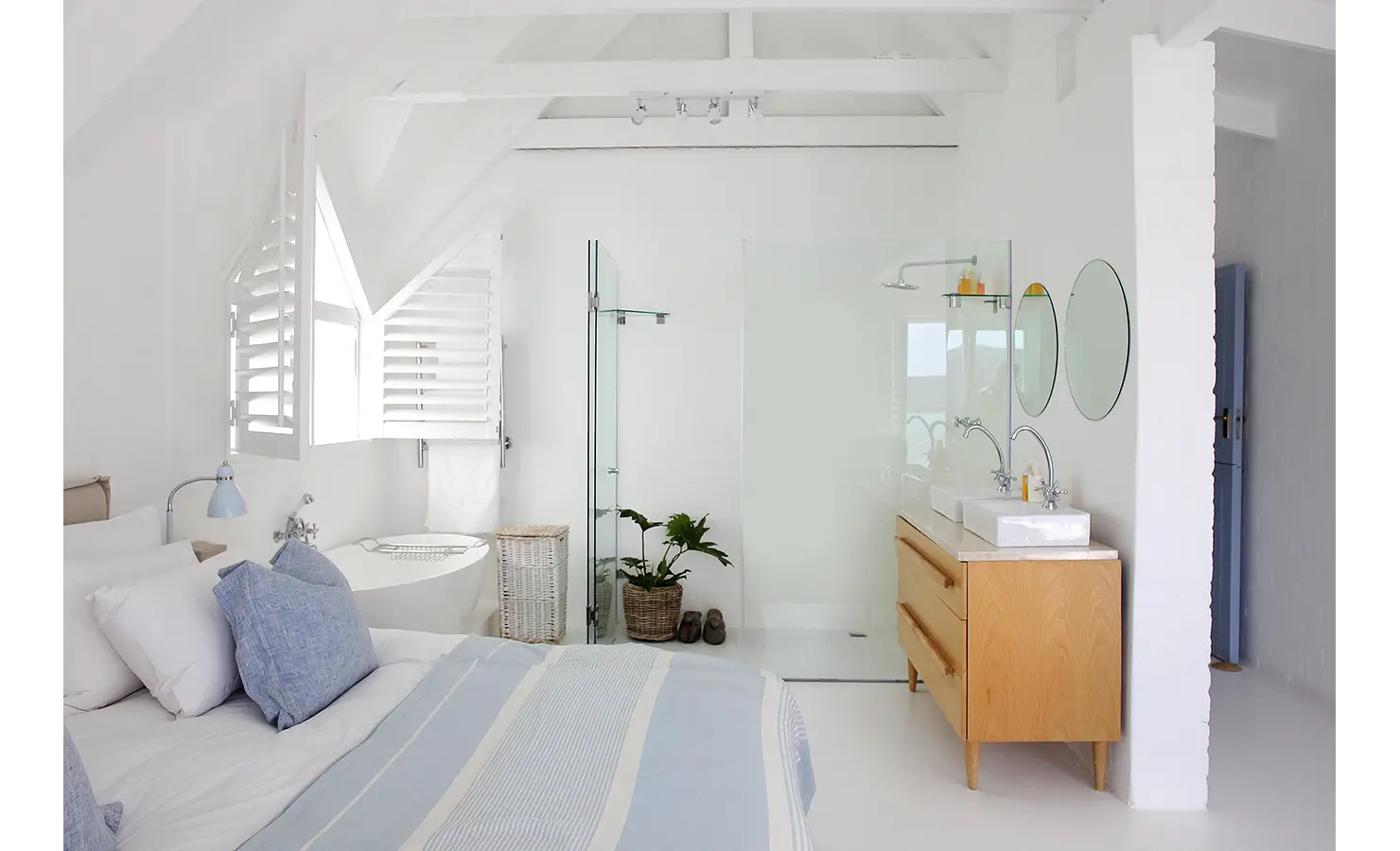 Perfect Hideaways: airy loft-style main suite with pitched beams, freestanding bath, glass shower and double vanity beside a soft blue bed, Langebaan, Lagoon Lookout.