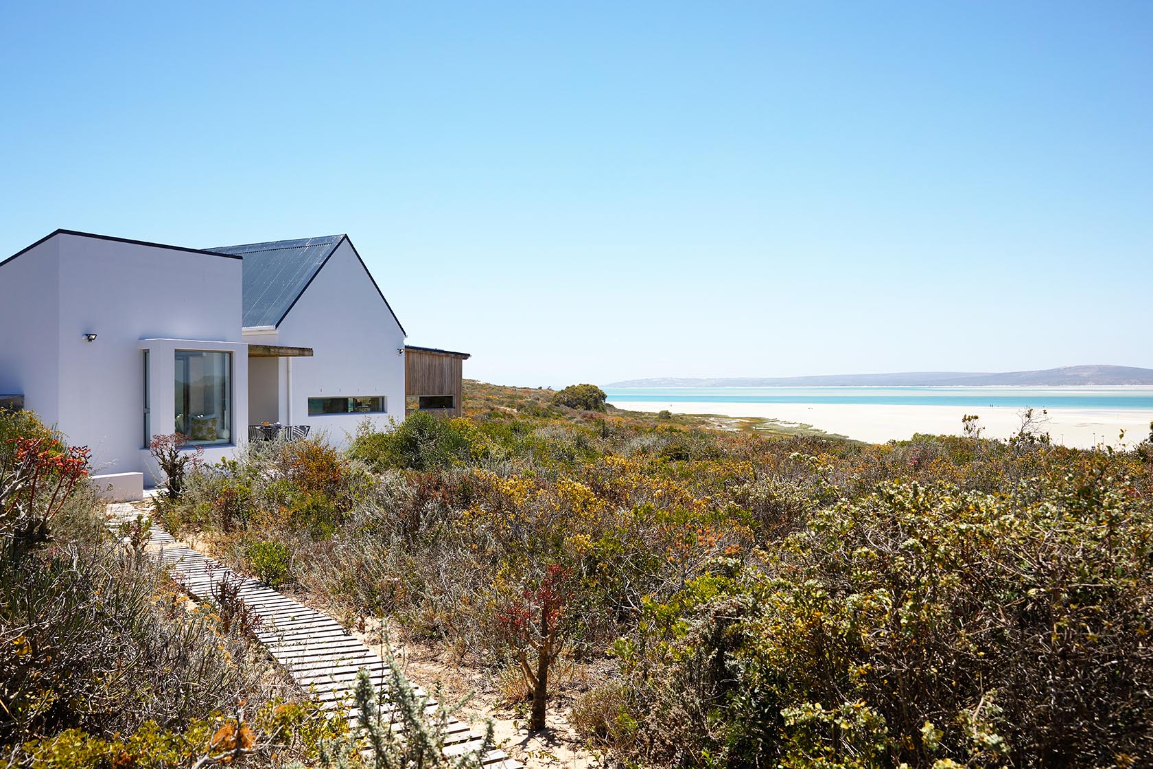 Perfect Hideaways coastal landscape with indigenous vegetation and expansive lagoon views under clear blue sky, Kalie's Cottage, Churchhaven
