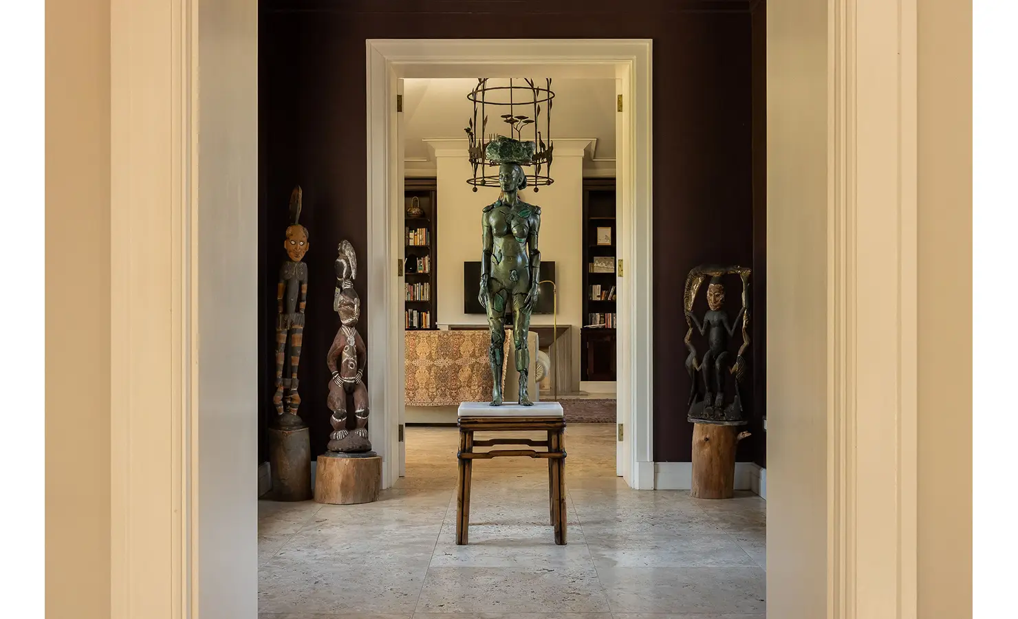 Perfect Hideaways art-filled hallway featuring a striking bronze sculpture framed by wooden tribal figures and warm lighting, Franschhoek, Varuna.