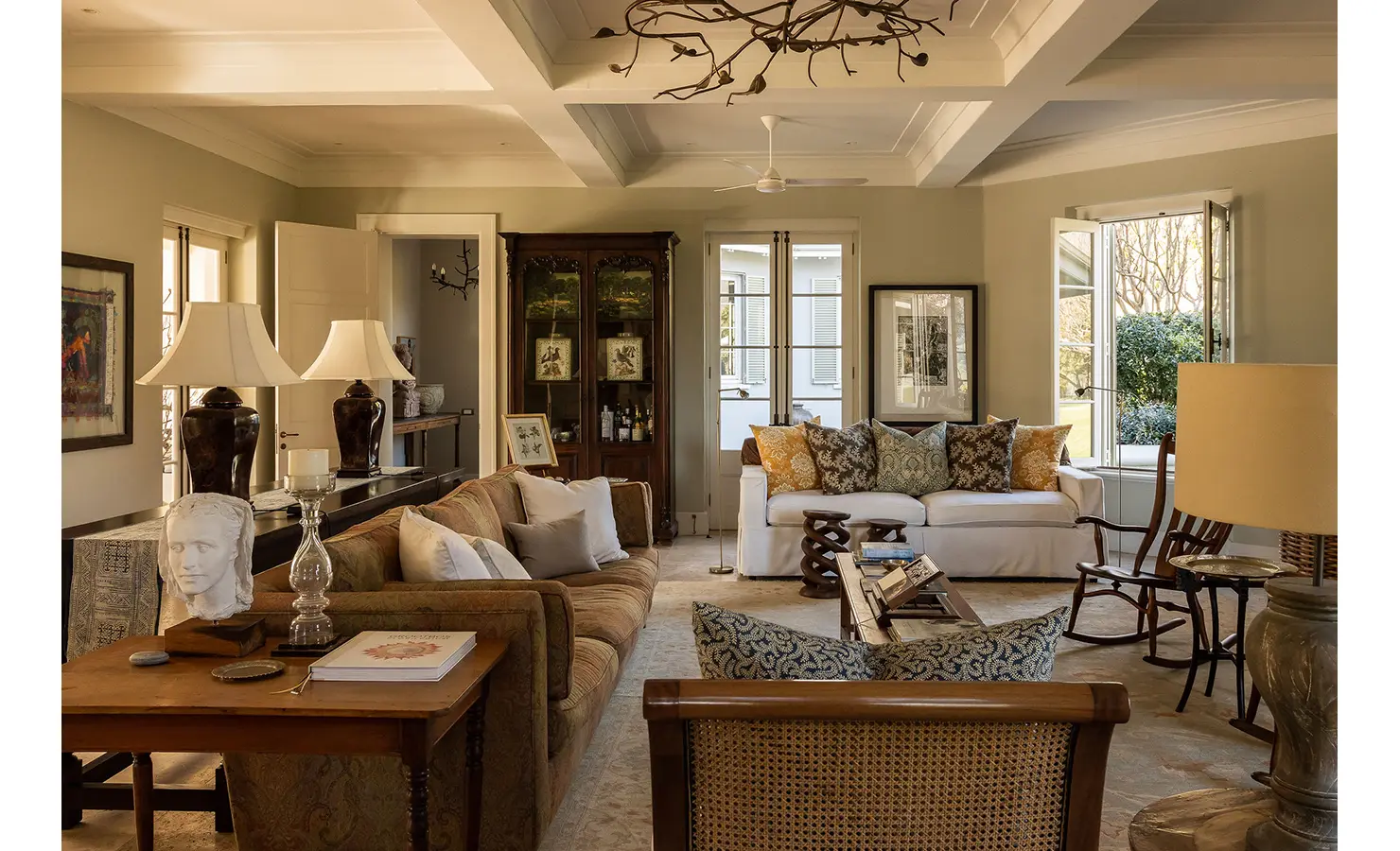Perfect Hideaways sophisticated living room with plush sofas, curated artwork, and natural light streaming through open windows, Franschhoek, Varuna.