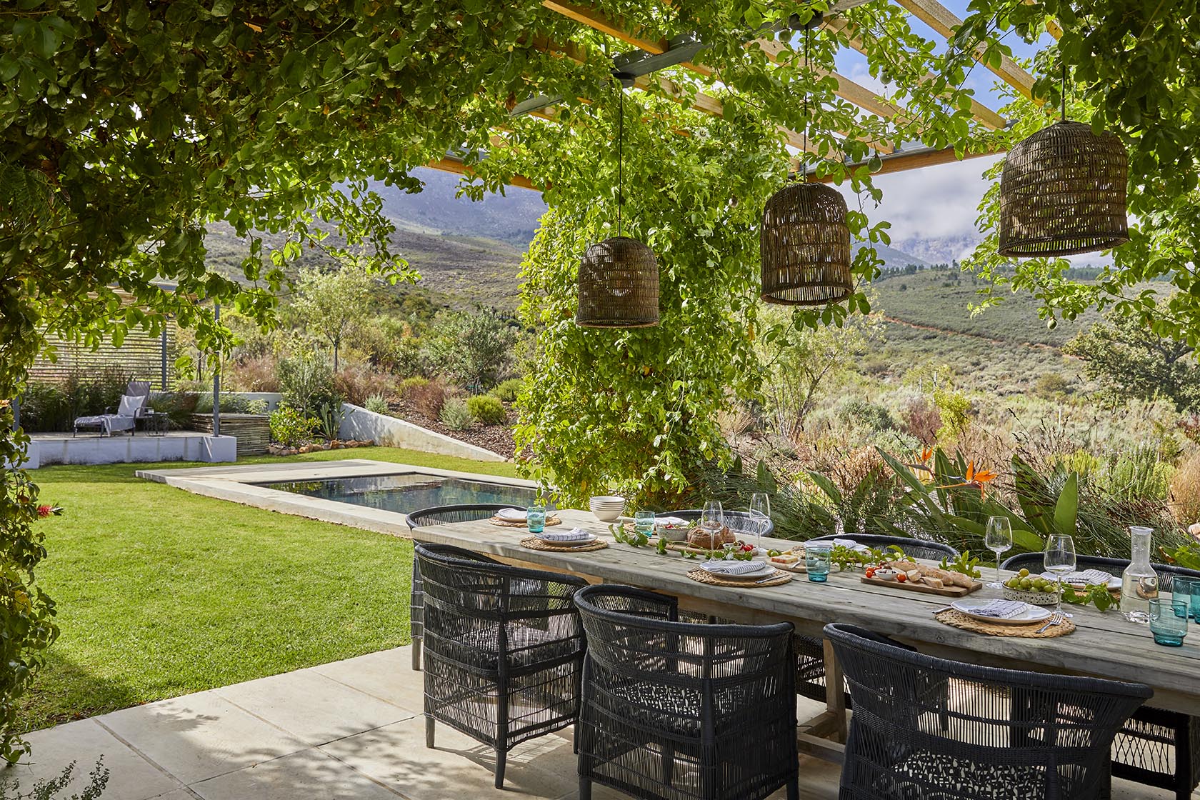 Perfect Hideaways - A shaded outdoor dining table set beneath a leafy pergola overlooking manicured lawns, a lap pool and mountain slopes dotted with fynbos High Country Cottage_Wolseley_Cape Winelands_Western Cape_South Africa