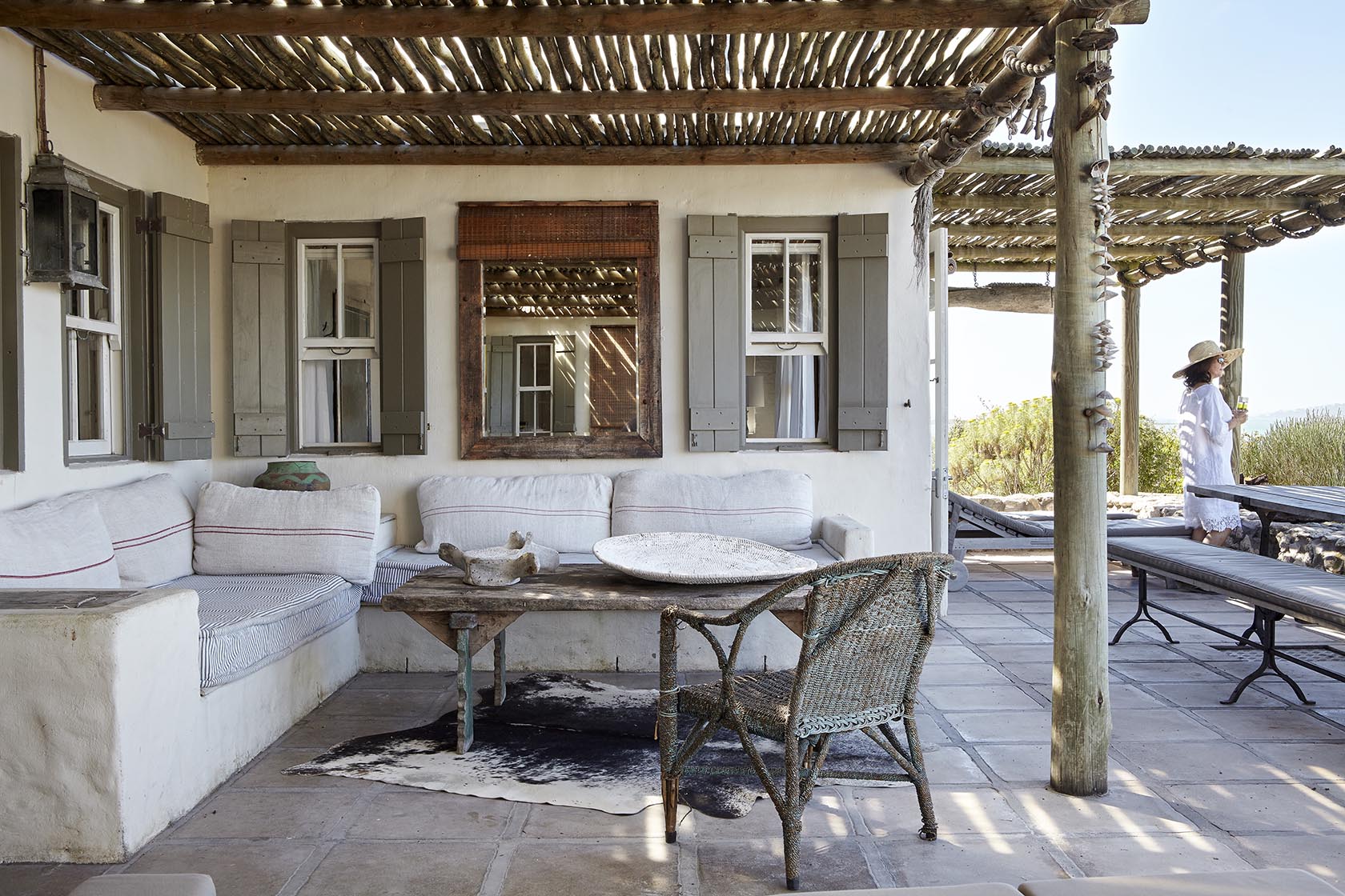 Perfect Hideaways - A rustic pergola-covered terrace with built-in seating, neutral cushions, a distressed wooden coffee table and woven chairs overlooking the surrounding coastal landscape Seagull Cottage_Churchhaven_West Coast_Western Cape_South Africa
