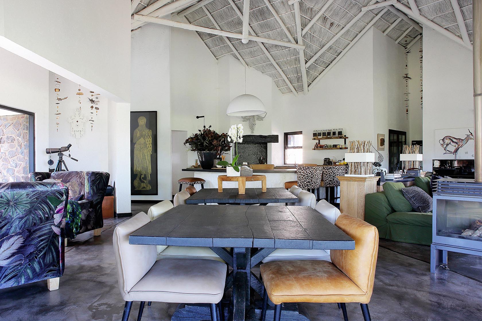 Perfect Hideaways - Open-plan living and dining space with vaulted thatched ceiling, long wooden dining table, eclectic seating, fireplace and curated African art Manor House Cypiro Leopard Lodge_Thabazimbi_Waterberg_Limpopo_South Africa