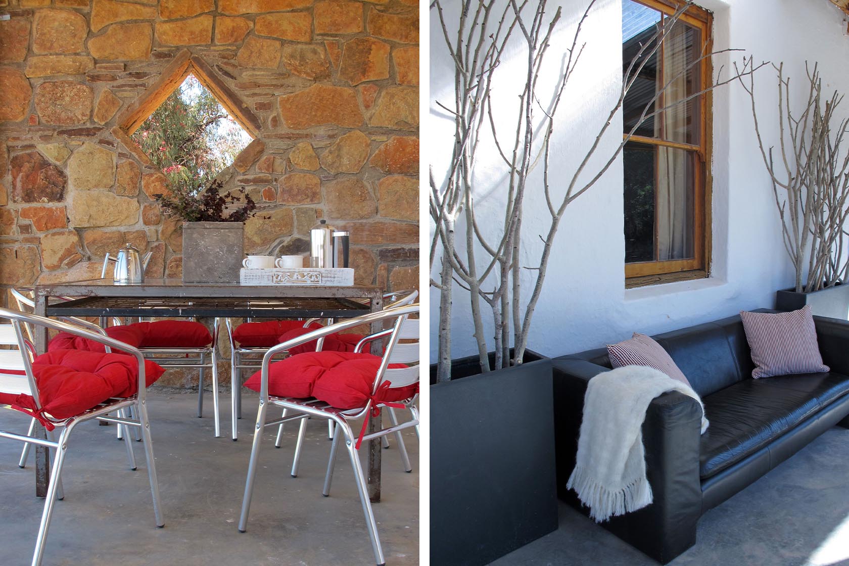 Perfect Hideaways- A sheltered stone-clad patio with a simple metal dining table and chairs topped with red cushions on one side, and on the other, a modern outdoor seating nook with a black sofa, striped cushions, and tall bare branches arranged in planter boxes. Karoo Cottage, Sneeuberg Nature Reserve, Eastern Cape, South Africa
