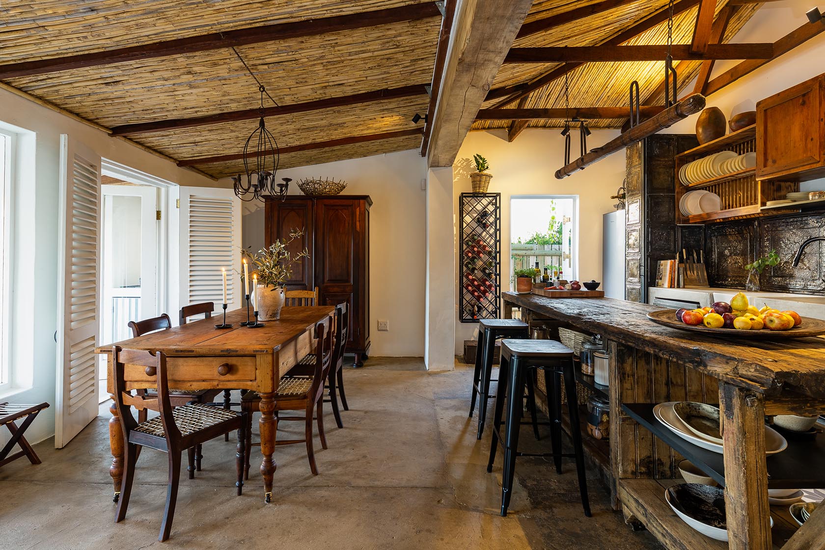 Perfect Hideaways-Spacious kitchen and dining area showcasing a farmhouse table, bar seating, open shelving, wine rack, and rustic finishes under a reed ceiling Valley Cottage, Riebeek Casteel, Western Cape, South Africa