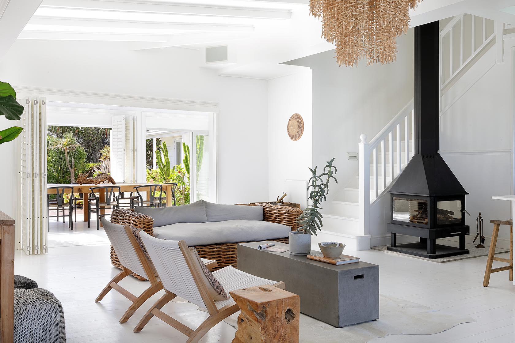 Perfect Hideaways - Spacious lounge with woven seating, neutral tones and a freestanding fireplace, connected to the dining area and staircase within a light-filled coastal interior Cape Cottage_Yzerfontein_West Coast_Western Cape_South Africa