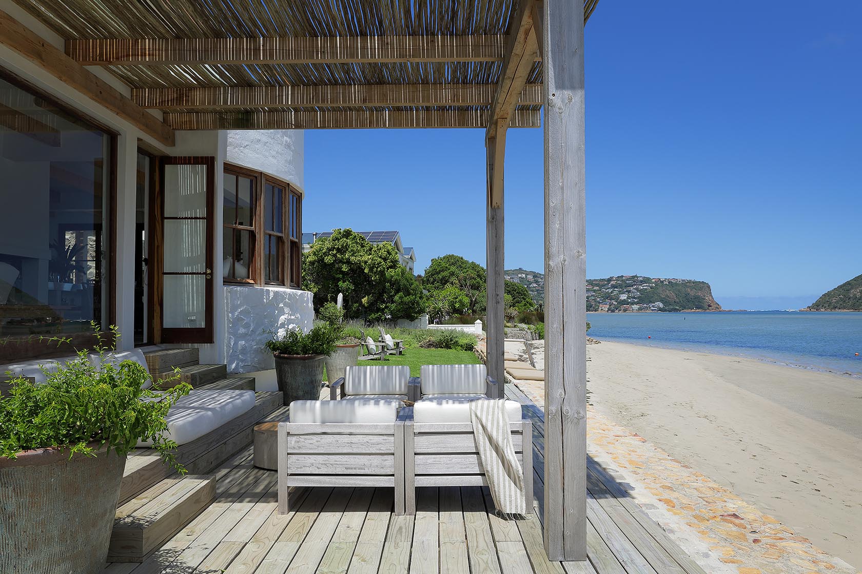 Perfect Hideaways: Pergola-shaded deck with cushioned seating opening directly onto the sandy lagoon beach, Knysna, Tides Reach