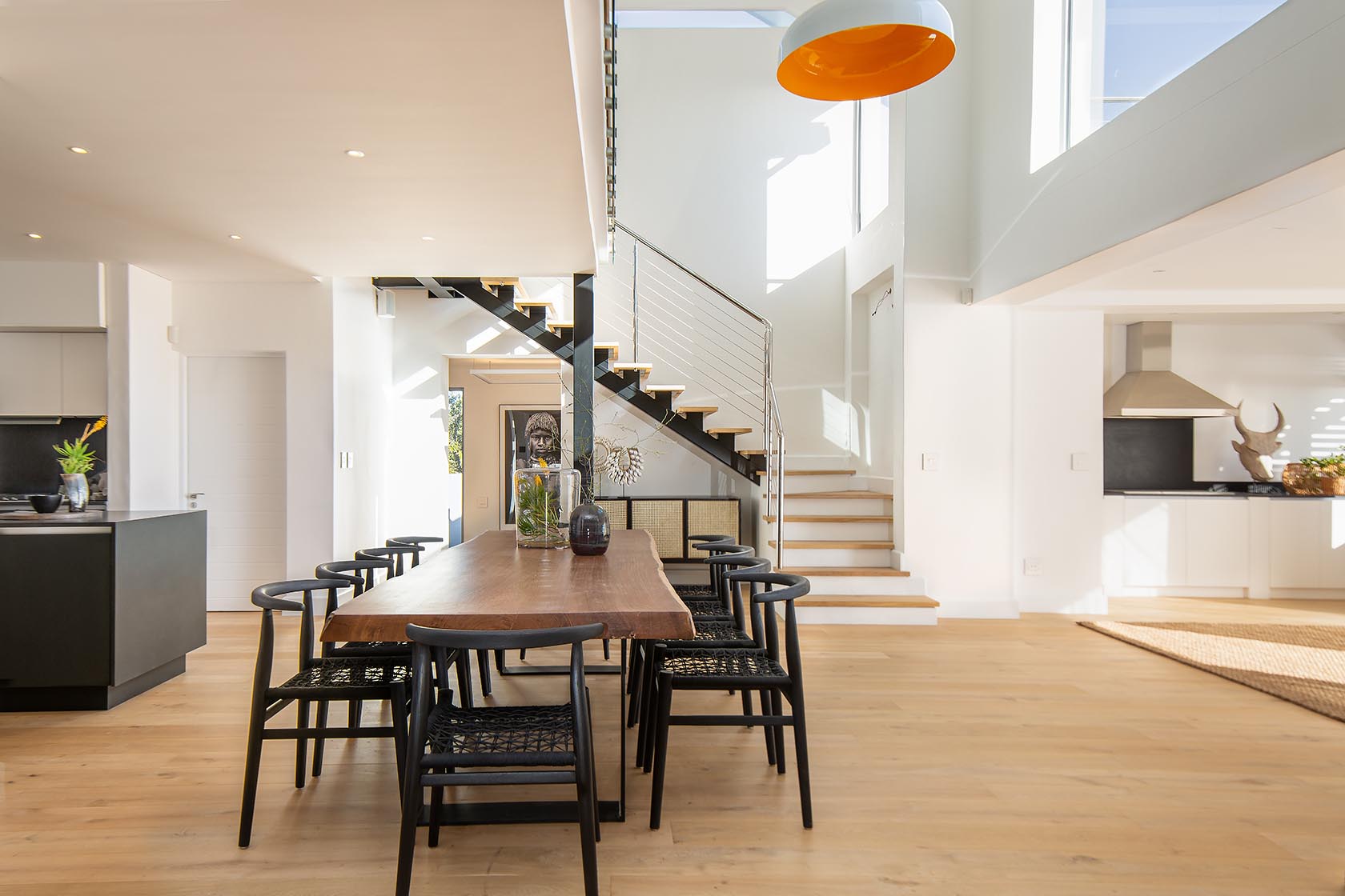 Perfect Hideaways - Modern open-plan dining area with wooden table, staircase and minimalist kitchen bathed in natural light Noordhoek Seashore_Noordhoek_Southern Peninsula_Cape Town_Western Cape_South Africa