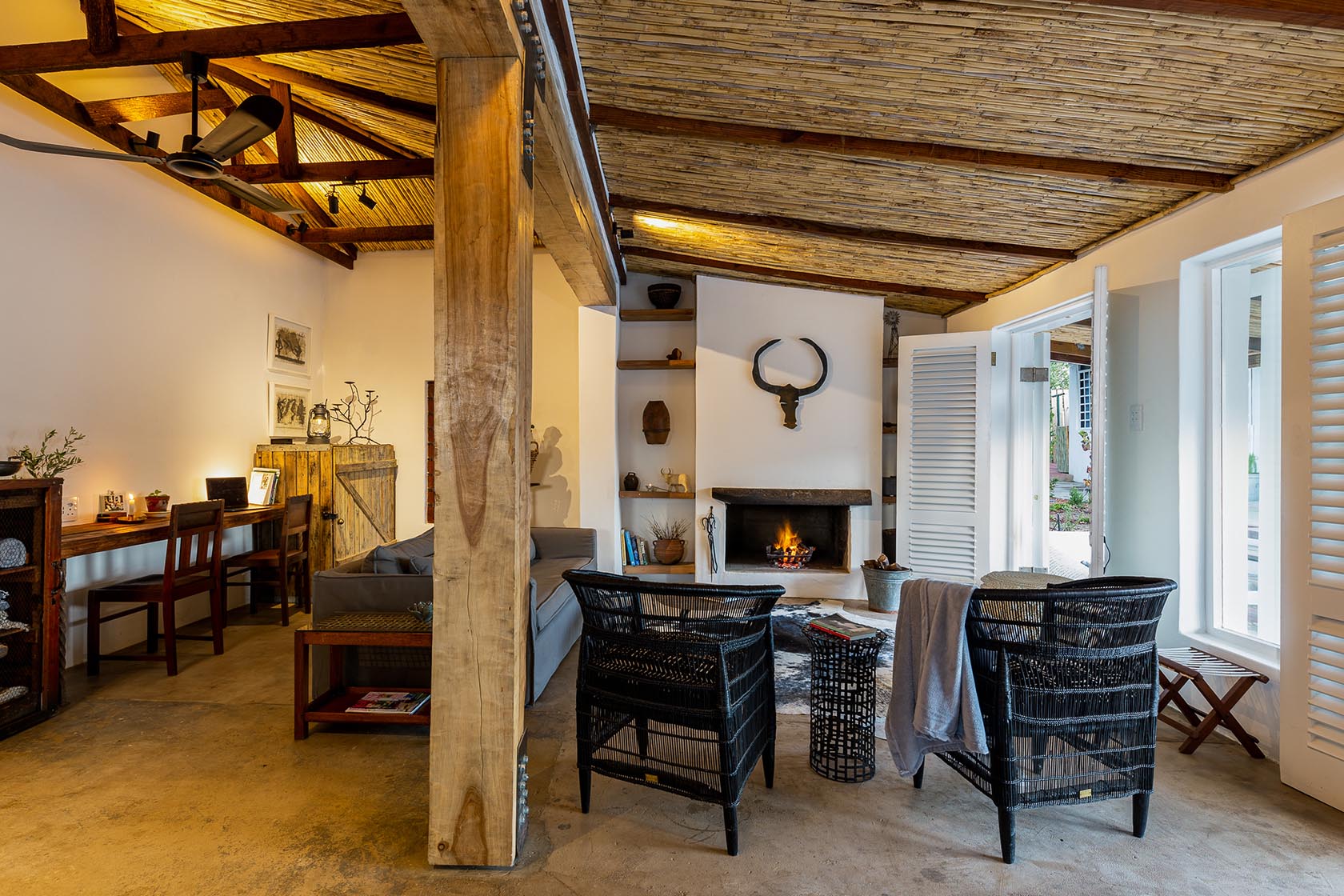 Perfect Hideaways-Warm living space with woven chairs, central fireplace, study nook, and exposed timber structure, opening onto the patio through shuttered doors Valley Cottage, Riebeek Casteel, Western Cape, South Africa