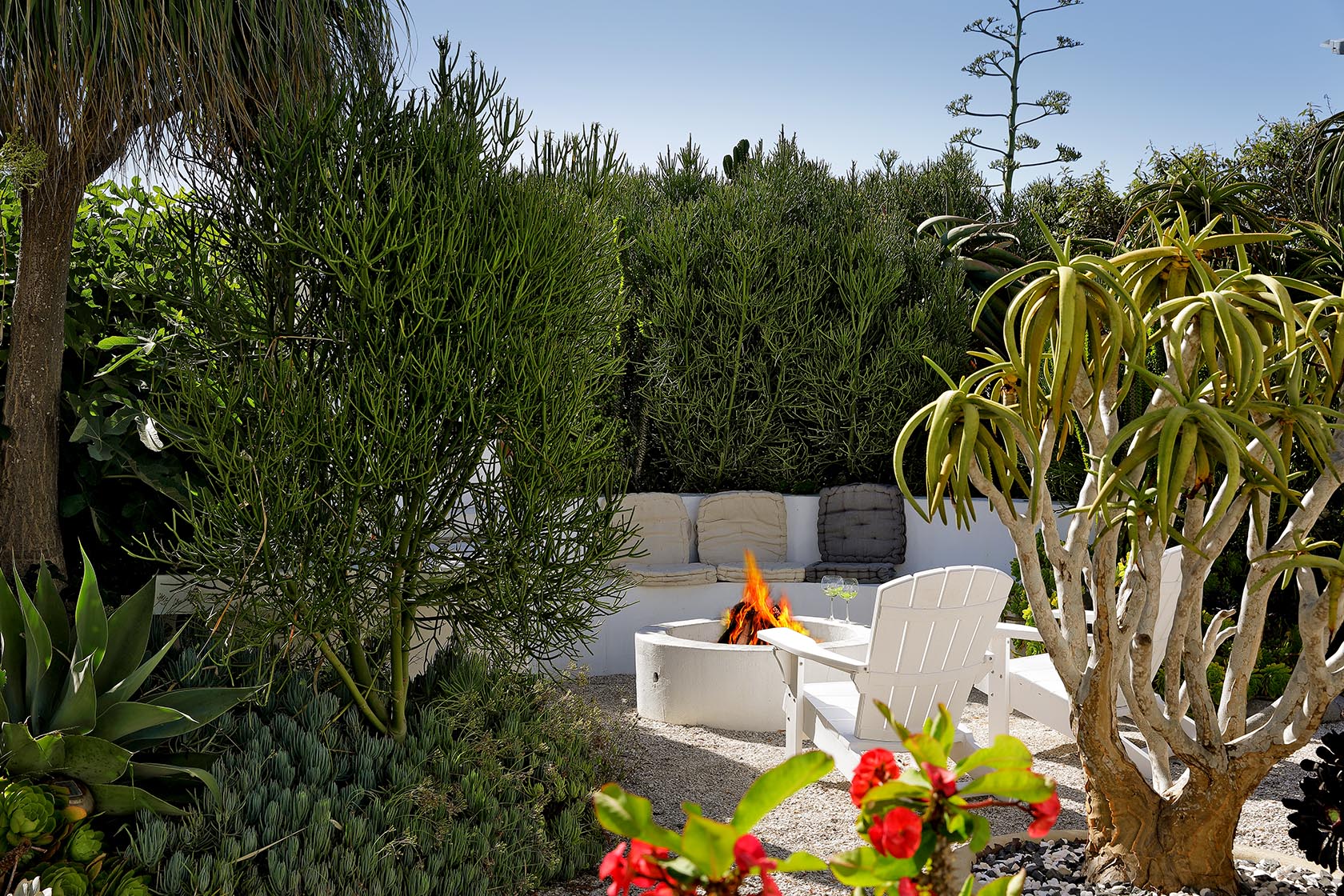 Perfect Hideaways - Secluded garden fire pit area with white Adirondack chairs set among lush succulents and coastal plants, creating an intimate outdoor retreat Cape Cottage_Yzerfontein_West Coast_Western Cape_South Africa