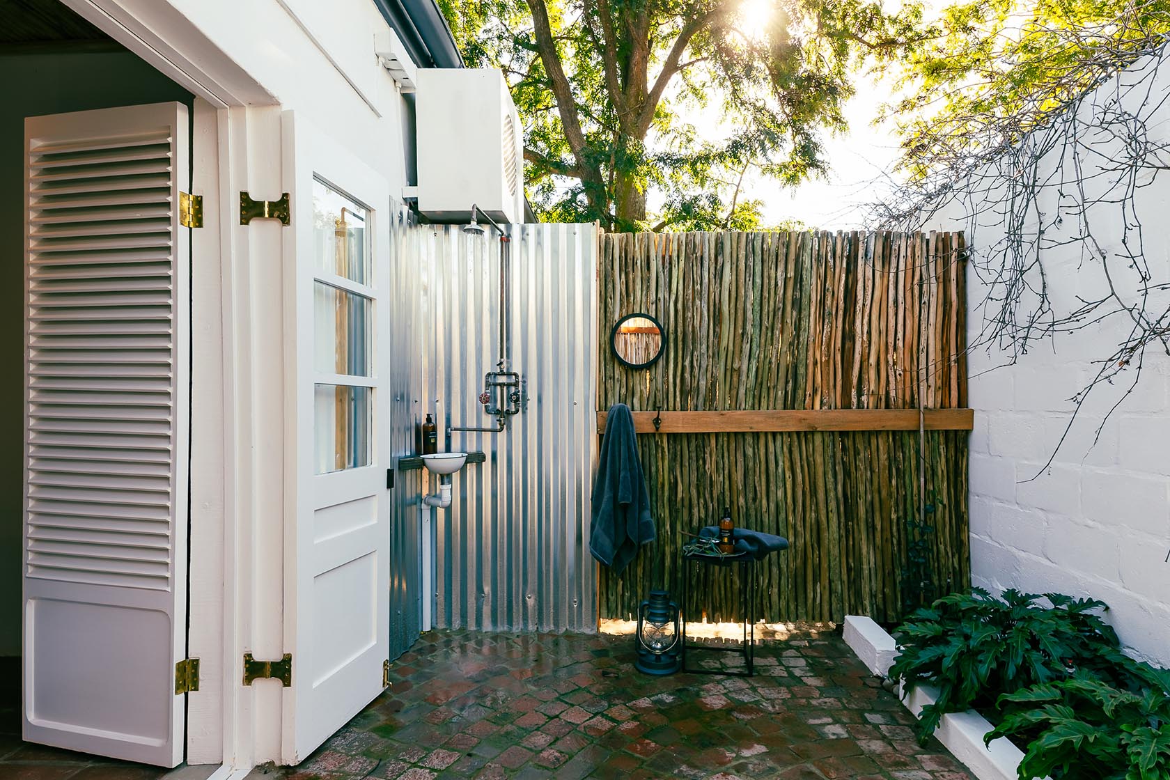 Perfect Hideaways-Outdoor shower courtyard with corrugated metal wall, timber screening, brick flooring, and natural light filtering through surrounding trees Valley Cottage, Riebeek Casteel, Western Cape, South Africa