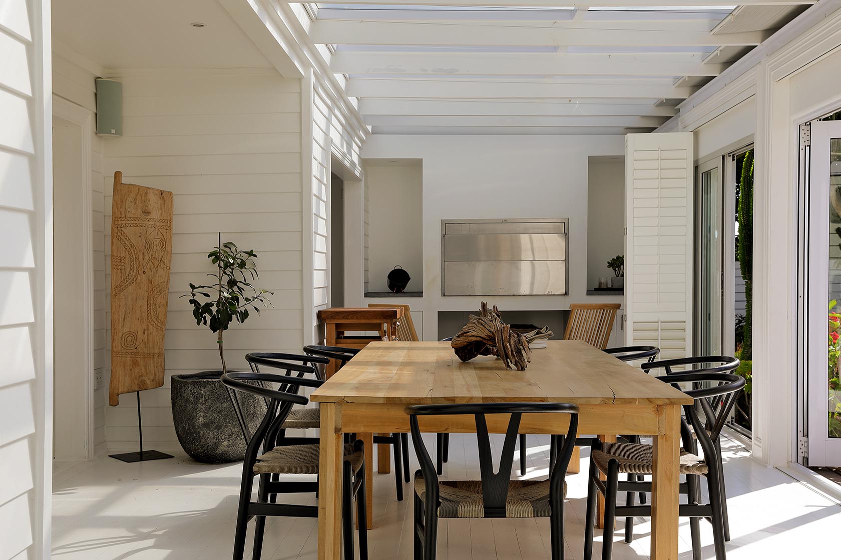 Perfect Hideaways - Light-filled indoor dining area with a long wooden table and black chairs, set beneath a glazed ceiling and opening to garden views through white shutters Cape Cottage_Yzerfontein_West Coast_Western Cape_South Africa
