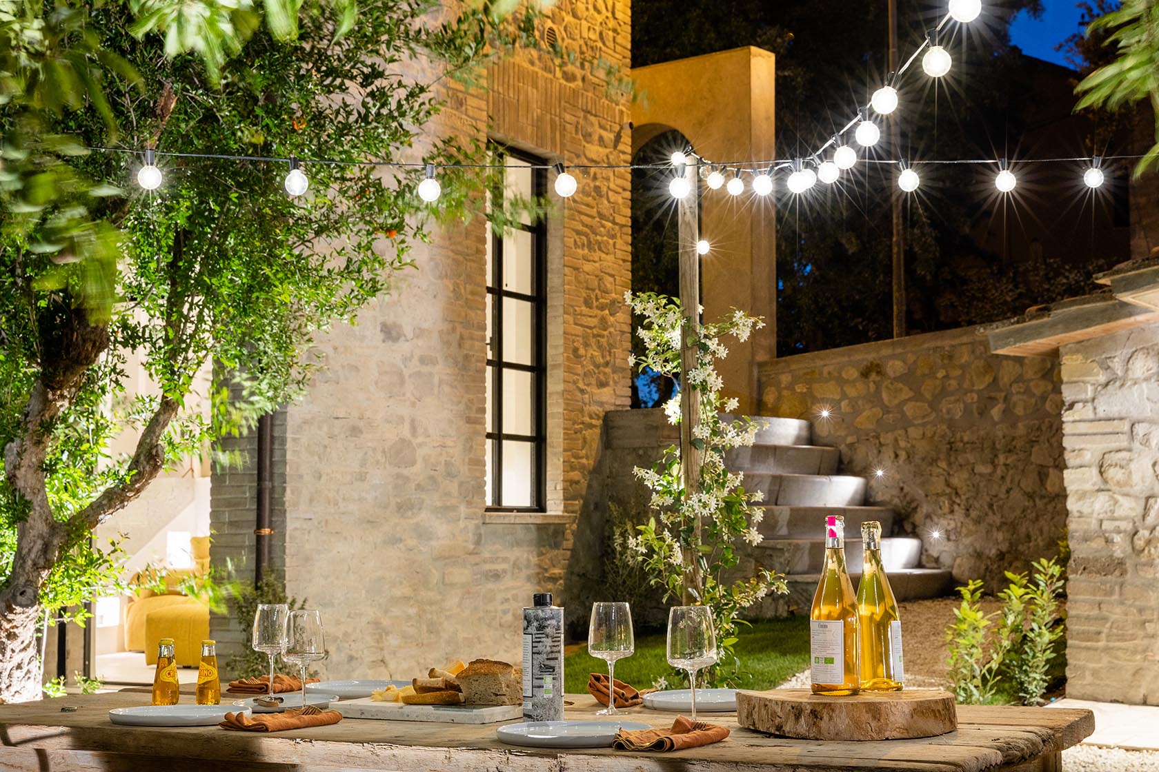 Perfect Hideaways charming evening dining terrace with string lights and stone architecture, Umbria Cottage, Collazzone